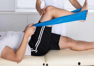 Physiotherapist Helping Patient While Exercising Physiotherapist Helping Patient While Stretching His Leg
